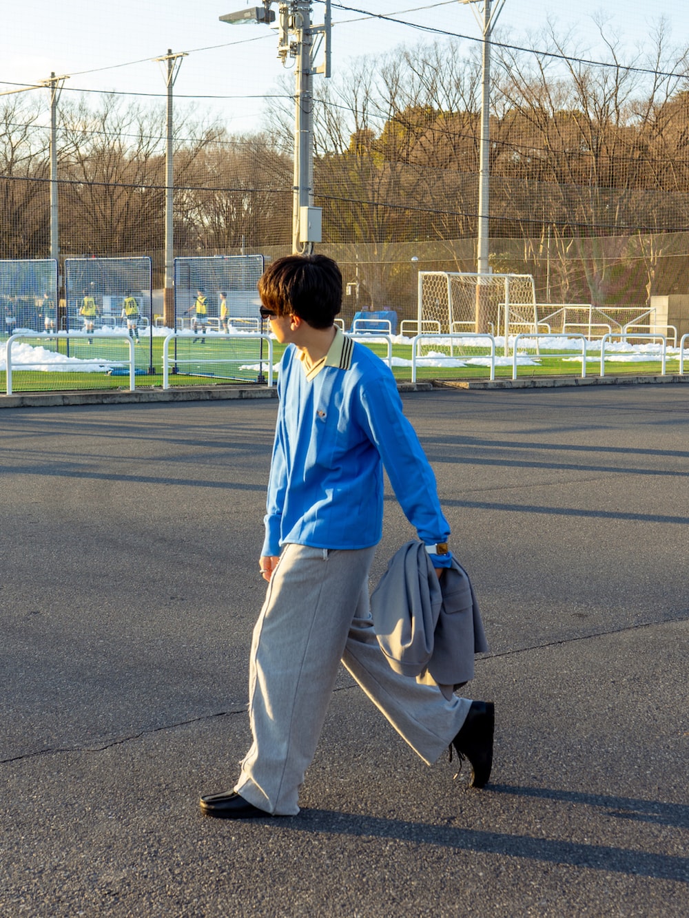 ブルー系のニット/セーター、グレー系のスウェットパンツ、ブラック系のブーツを着用したメンズの冬コーディネートの3枚目の写真