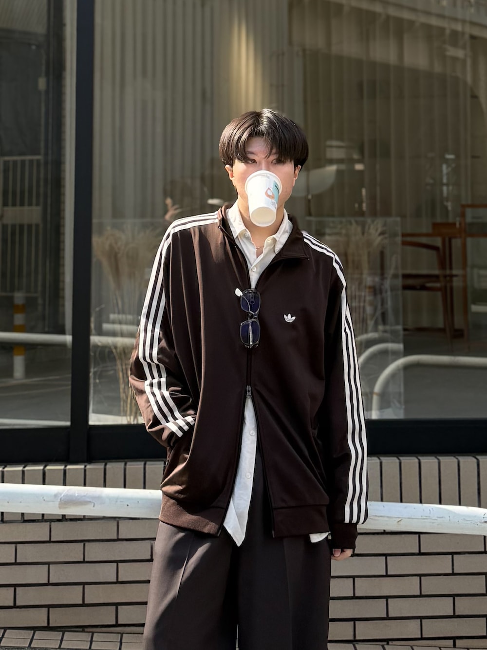 ブラウン系のジャージ、ブラック系のモカシン/デッキシューズ、ブラウン系のサングラスを着用したメンズの秋コーディネートの3枚目の写真