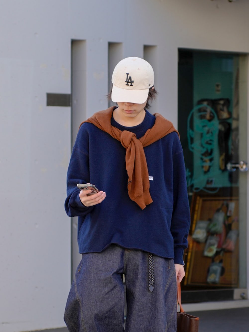 ブルー系のスウェット、ブラウン系のカーディガン/ボレロ、ブルー系のデニムパンツを着用したメンズの冬コーディネートの4枚目の写真