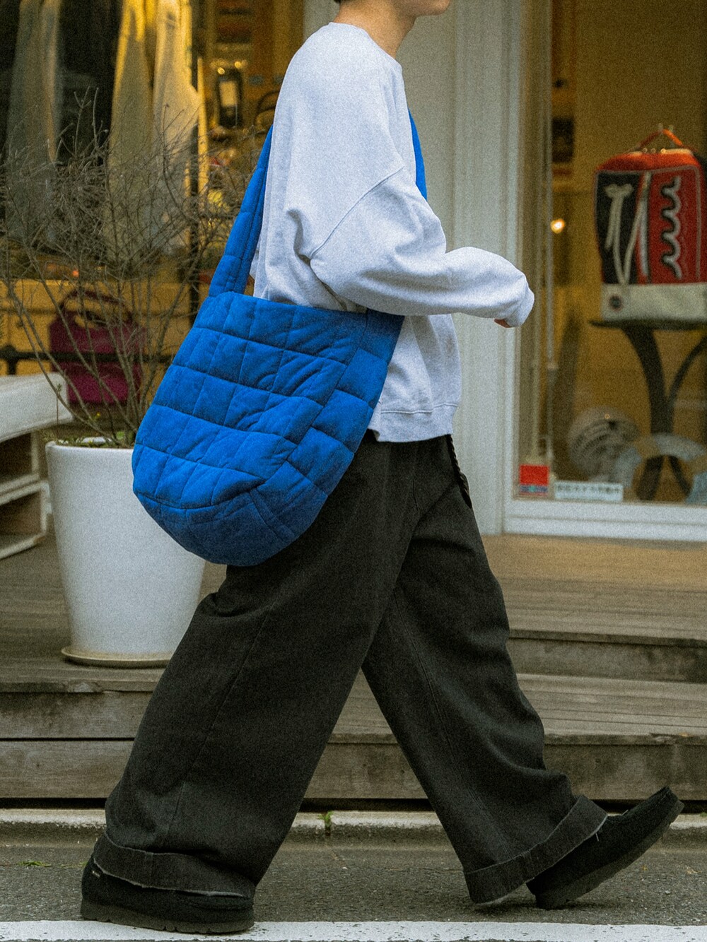 グレー系のスウェット、ブラック系のデニムパンツ、ブルー系のショルダーバッグを着用したメンズの春コーディネートの5枚目の写真