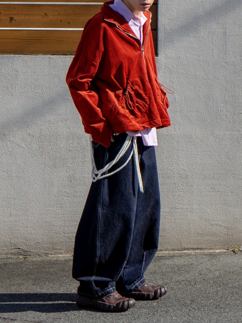 オレンジ系のブルゾン、ピンク系のシャツ/ブラウス、ブルー系のデニムパンツを着用したメンズの秋コーディネートの5枚目の写真