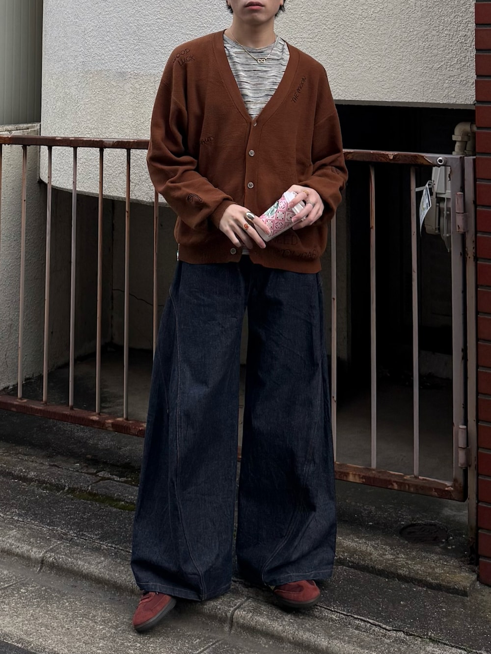 ブラウン系のカーディガン/ボレロ、グレー系のTシャツ/カットソー、ブルー系のデニムパンツを着用したメンズの春コーディネートの4枚目の写真