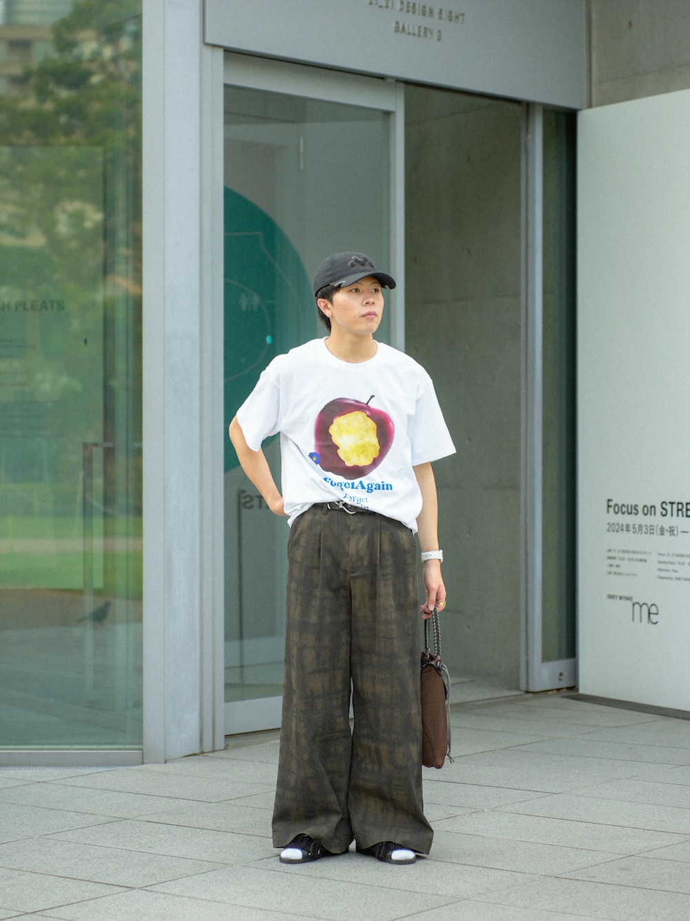 レッド系のTシャツ/カットソー、グリーン系のその他パンツ、ブラウン系のショルダーバッグを着用したメンズの夏コーディネートの3枚目の写真