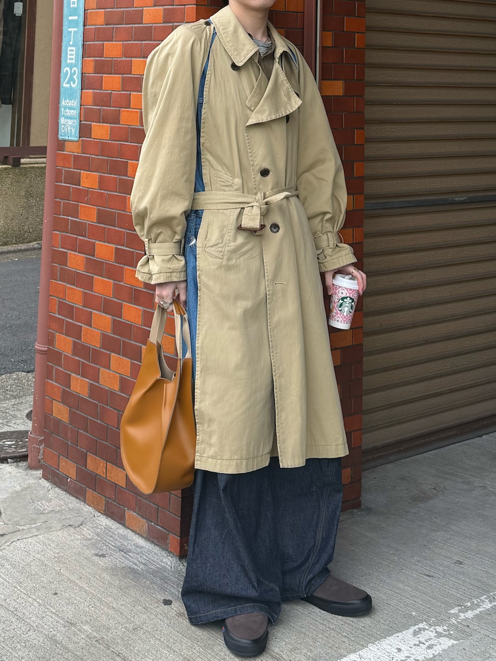 ベージュ系のトレンチコート、グリーン系のシャツ/ブラウス、グレー系のTシャツ/カットソーを着用したメンズの春コーディネートの5枚目の写真