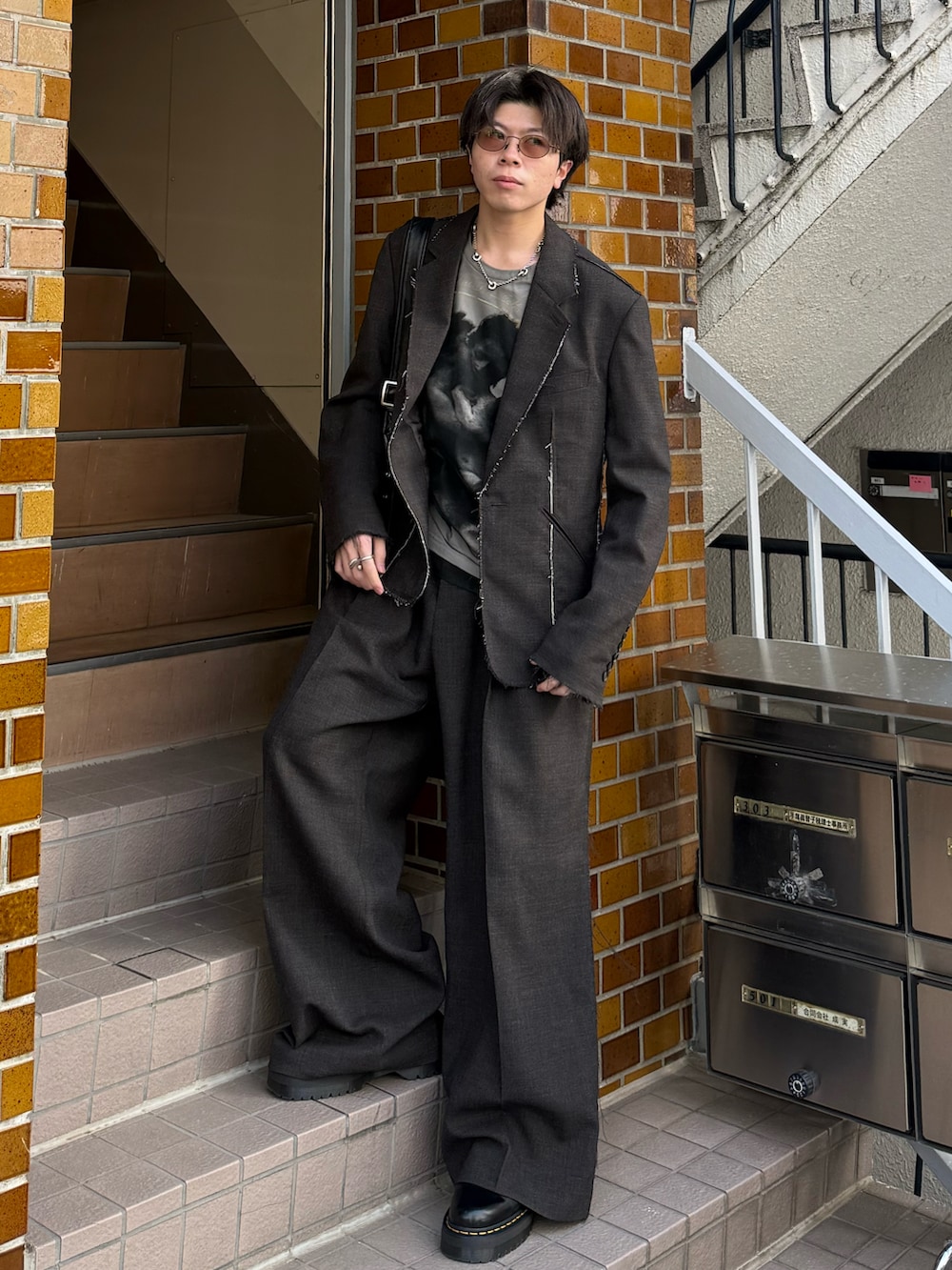 ブラック系のブーツ、ホワイト系のTシャツ/カットソー、ブラック系のショルダーバッグを着用したメンズの春コーディネートの2枚目の写真