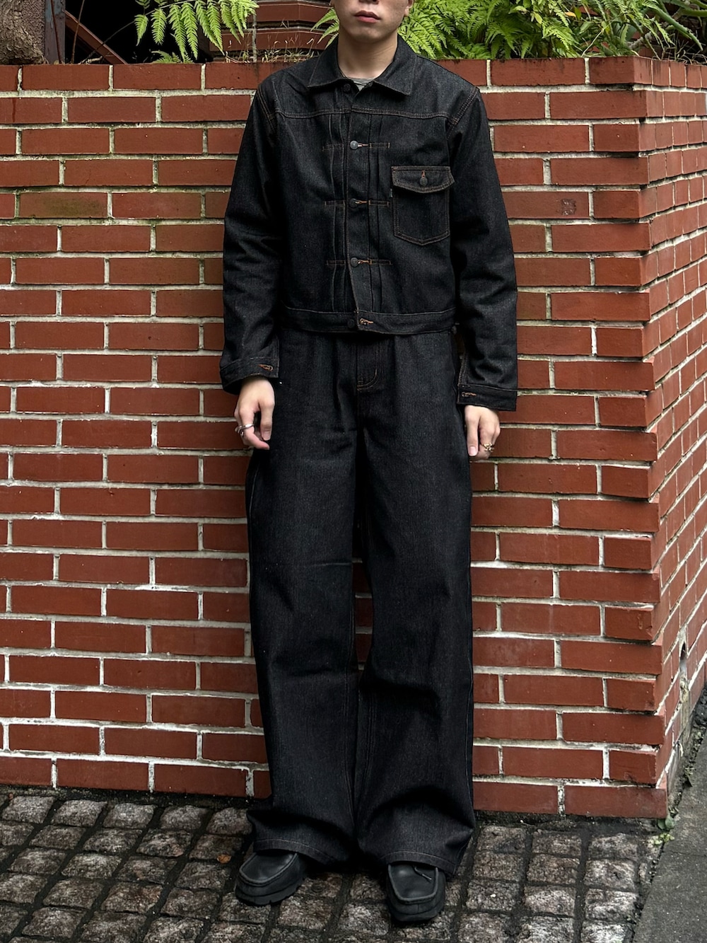ブラック系のデニムジャケット、ブラック系のデニムパンツ、グレー系のTシャツ/カットソーを着用したメンズの秋コーディネートの3枚目の写真