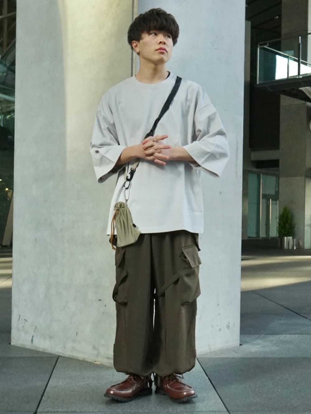 グレー系のTシャツ/カットソー、グリーン系のサロペット/オーバーオール、ベージュ系のショルダーバッグを着用したメンズの冬コーディネートの2枚目の写真