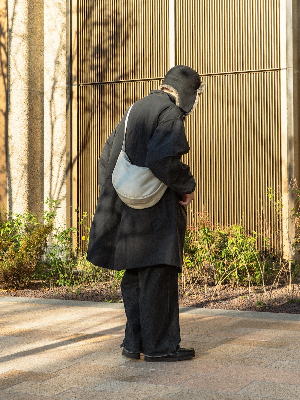 ブラック系のモッズコート、ブラック系のデニムパンツ、ブラック系のブーツを着用したメンズの冬コーディネートの5枚目の写真