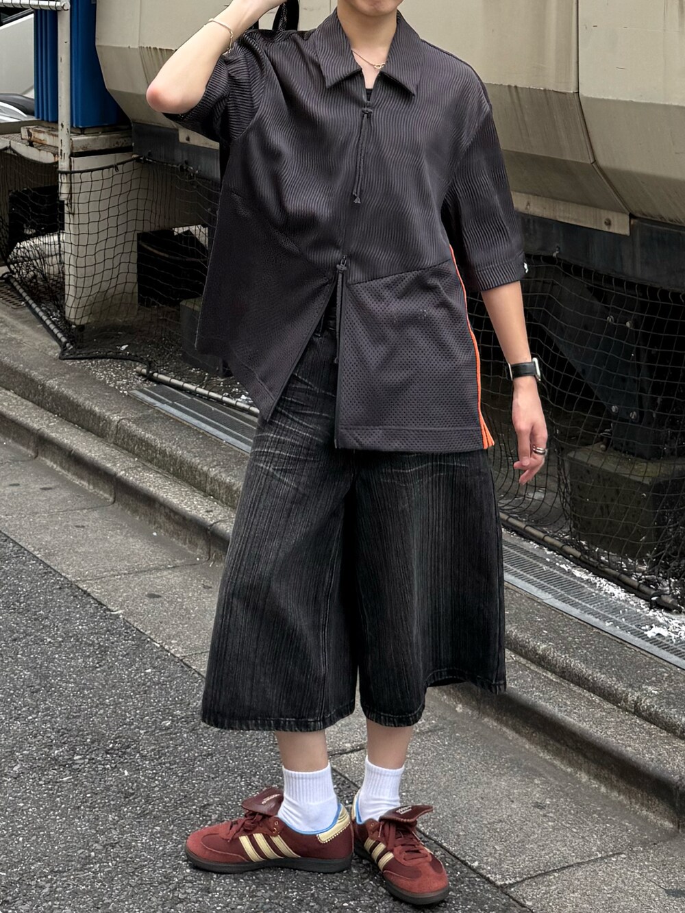 グレー系のデニムパンツ、ブラック系のショルダーバッグ、グレー系のトップスを着用したメンズの夏コーディネートの3枚目の写真