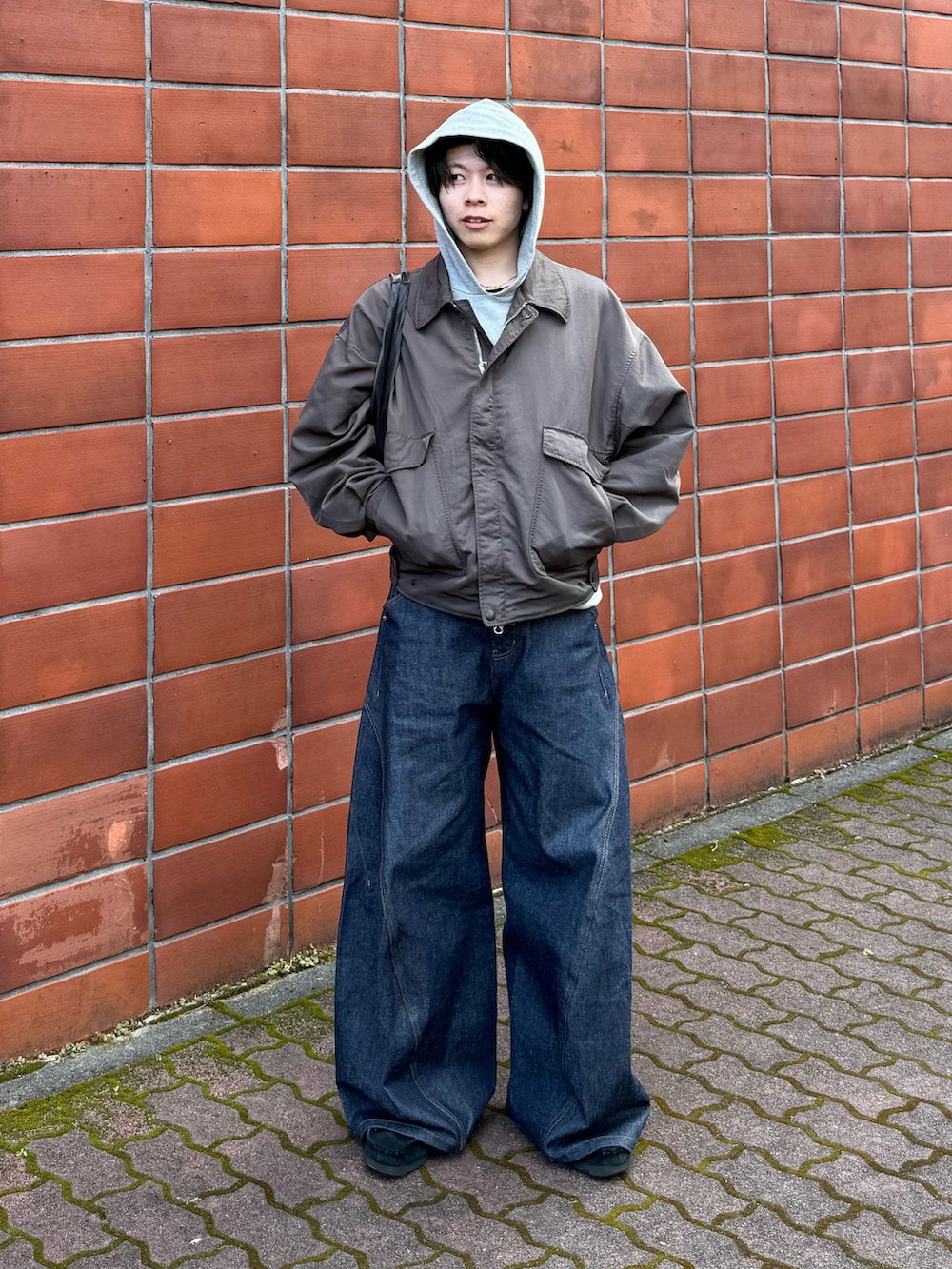 ブルー系のデニムパンツ、ブラック系のその他シューズ、グレー系のナイロンジャケットを着用したメンズの春コーディネートの2枚目の写真
