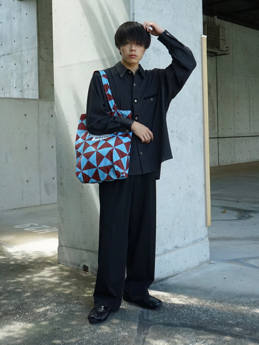 グレー系のシャツ/ブラウス、ブラック系のスラックス、ブルー系のトートバッグを着用したメンズの夏コーディネートの2枚目の写真