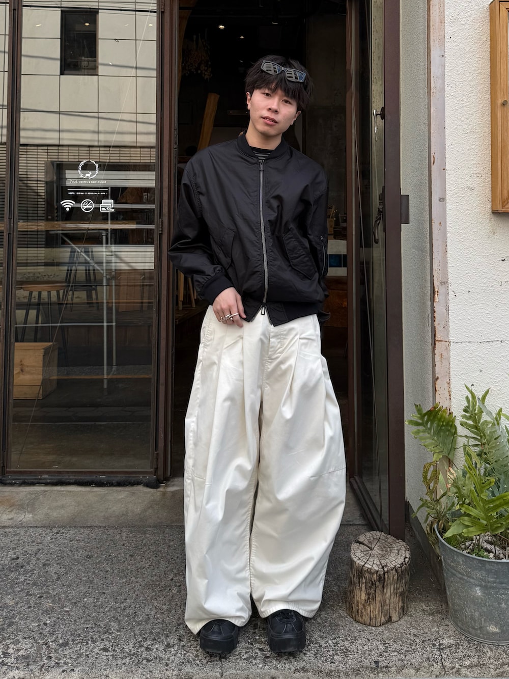 ブラック系のTシャツ/カットソー、ブラック系のブルゾン、ホワイト系のその他パンツを着用したメンズの春コーディネートの2枚目の写真