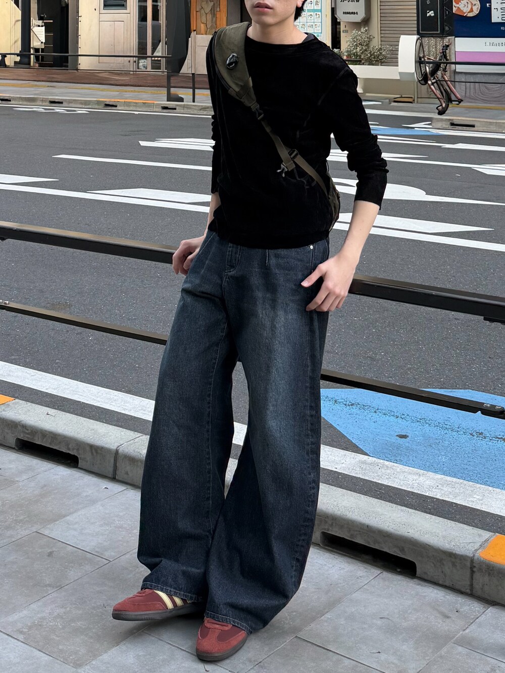 ブラック系のTシャツ/カットソー、ブルー系のデニムパンツ、グリーン系のバックパック/リュックを着用したメンズの春コーディネートの2枚目の写真
