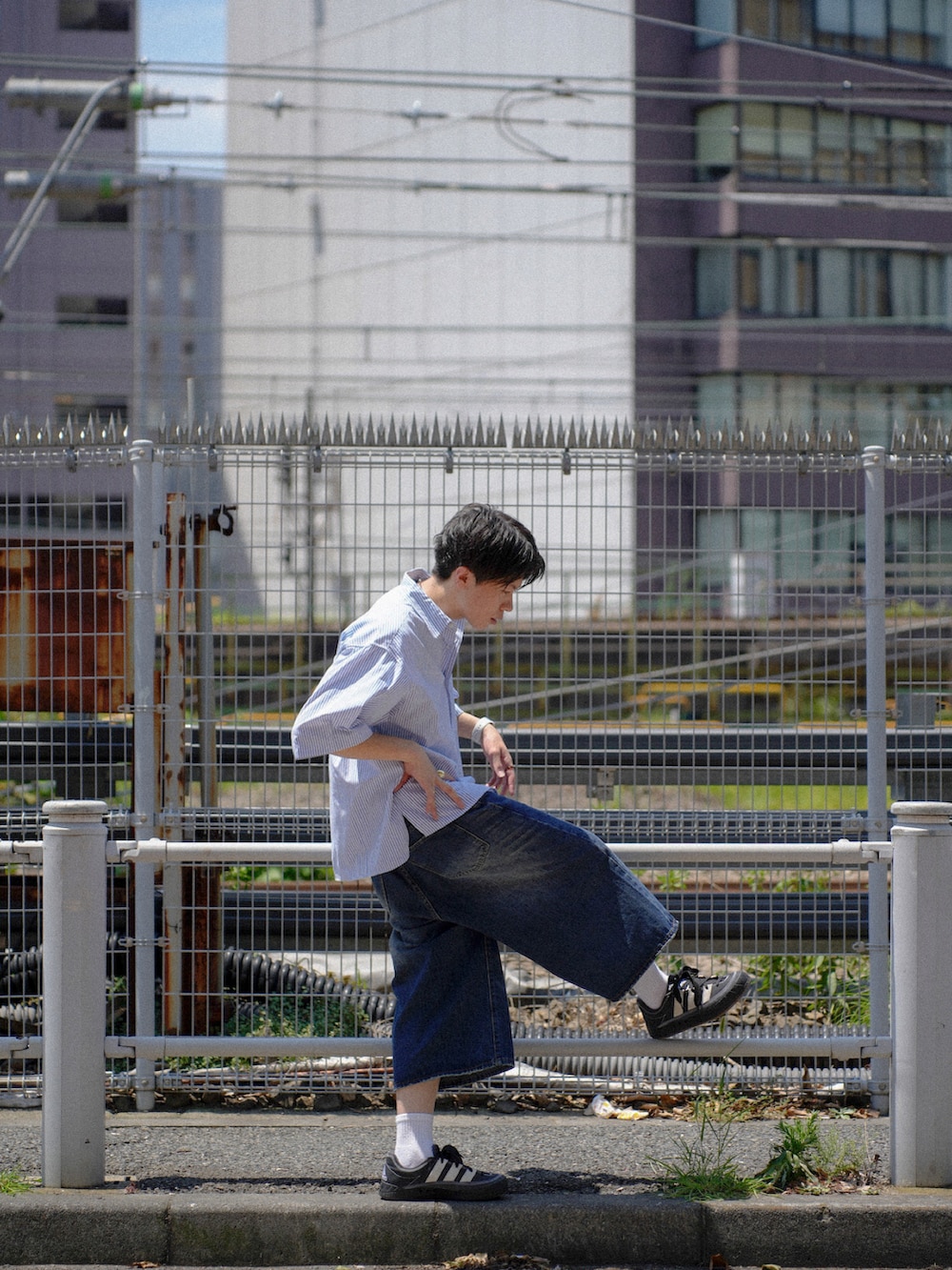 ホワイト系のシャツ/ブラウス、ブルー系のデニムパンツ、ブラック系のスニーカーを着用したメンズの夏コーディネートの3枚目の写真