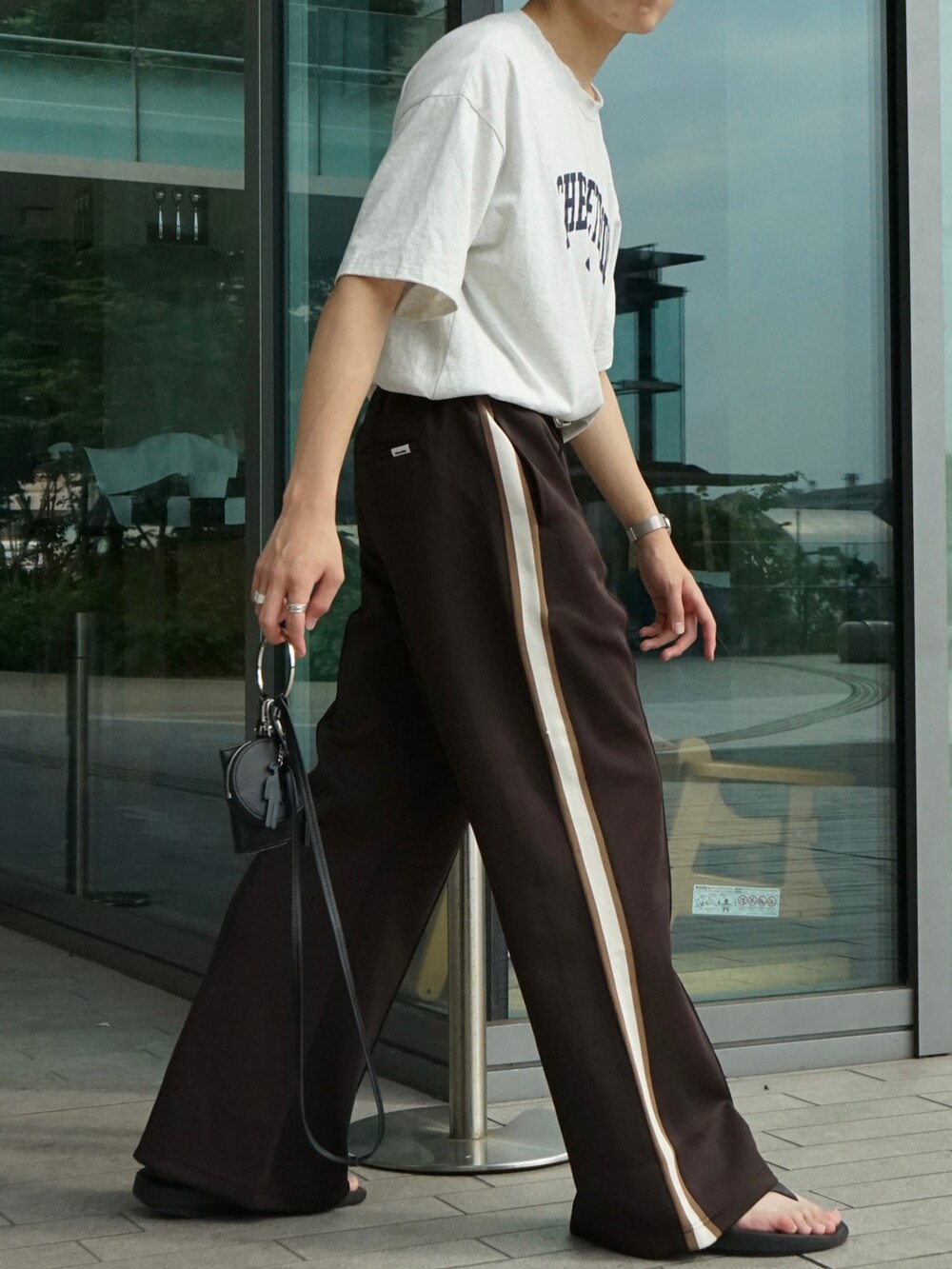 グレー系のTシャツ/カットソー、ブラウン系のその他パンツ、ブラック系のショルダーバッグを着用したメンズの夏コーディネートの5枚目の写真