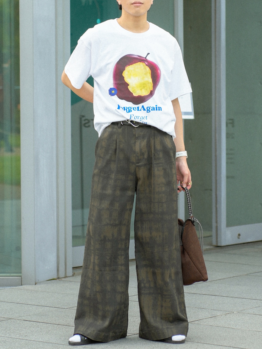 レッド系のTシャツ/カットソー、グリーン系のその他パンツ、ブラウン系のショルダーバッグを着用したメンズの夏コーディネートの5枚目の写真