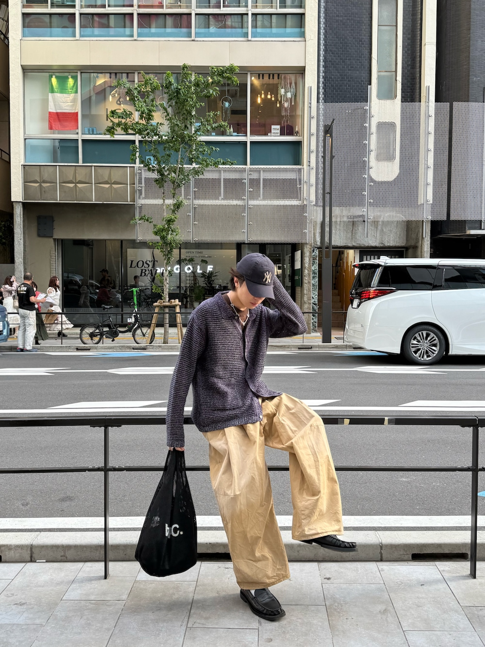 パープル系のカーディガン/ボレロ、ブラウン系のTシャツ/カットソー、ベージュ系のチノパンツを着用したメンズの春コーディネートの3枚目の写真