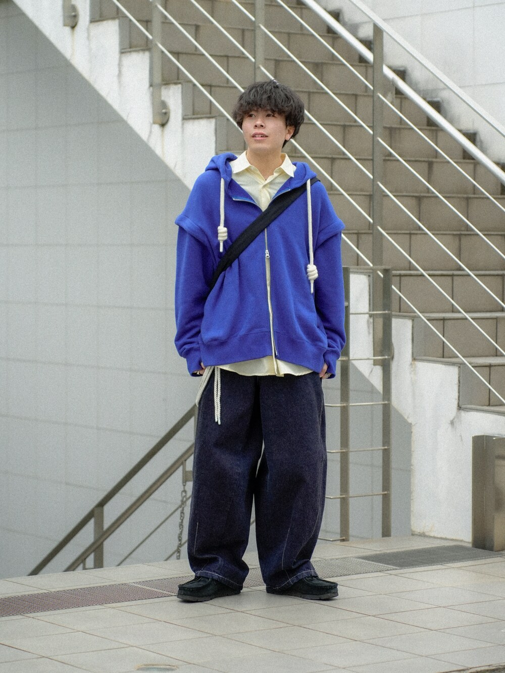 ブルー系のパーカー、イエロー系のシャツ/ブラウス、ブルー系のデニムパンツを着用したメンズの春コーディネートの2枚目の写真