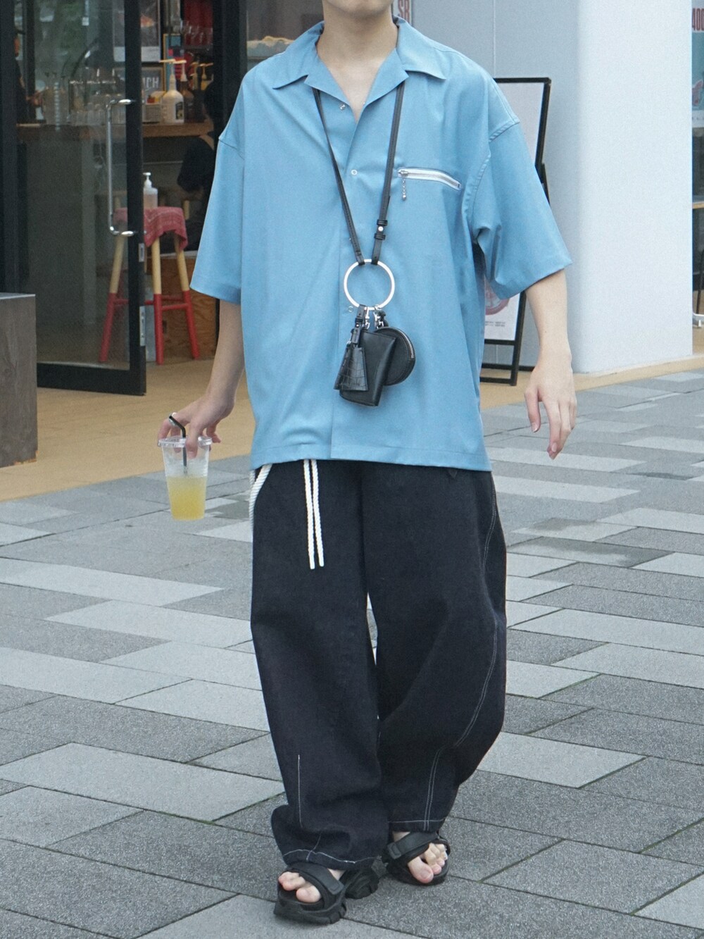 ブルー系のデニムパンツ、ブラック系のショルダーバッグ、ブラック系のサンダルを着用したメンズの夏コーディネートの5枚目の写真