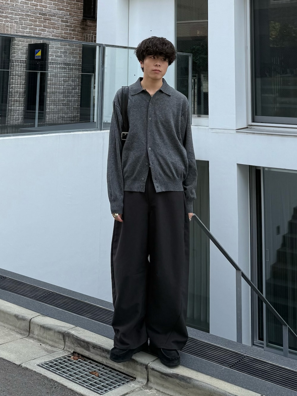 グレー系のシャツ/ブラウス、グレー系のスラックス、ブラック系のショルダーバッグを着用したメンズの秋コーディネートの2枚目の写真