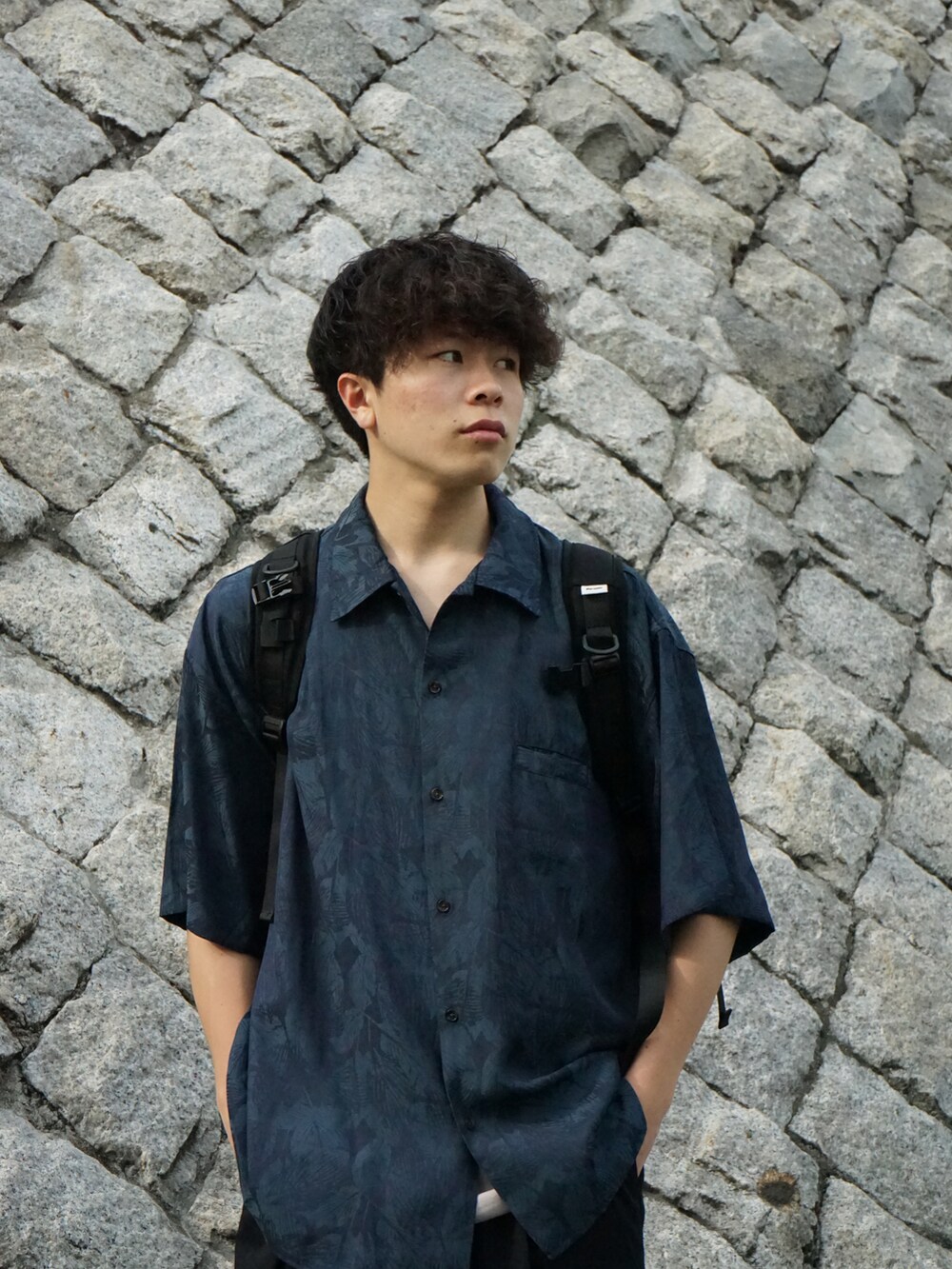 グリーン系のシャツ/ブラウス、グレー系のタンクトップ、ブラック系のバックパック/リュックを着用したメンズの春コーディネートの5枚目の写真