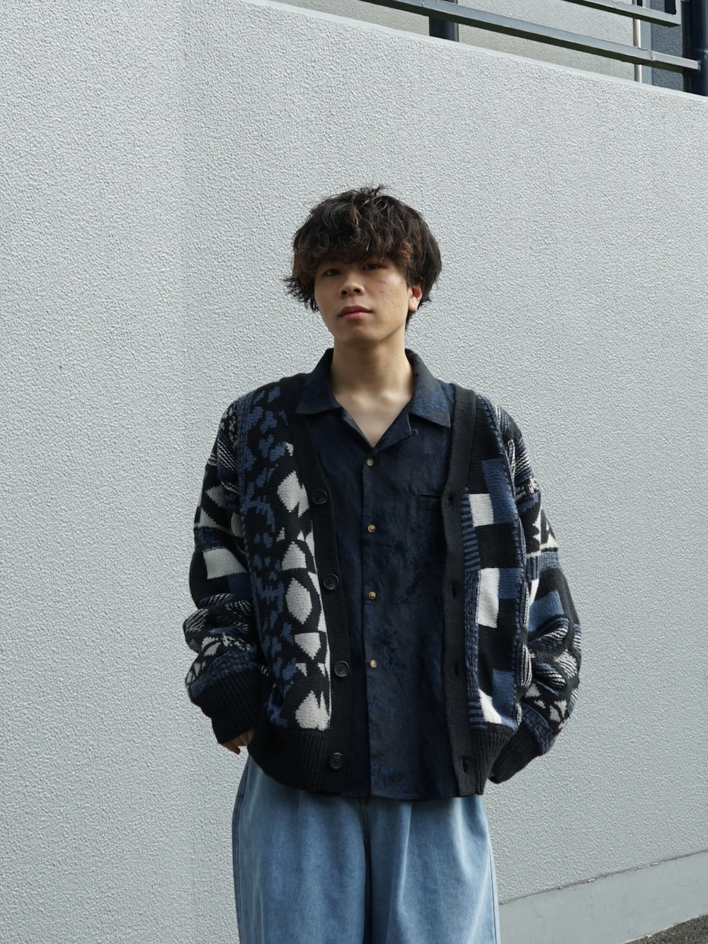 ブルー系のカーディガン/ボレロ、ブルー系のスラックス、ブラック系のブーツを着用したメンズの秋コーディネートの4枚目の写真