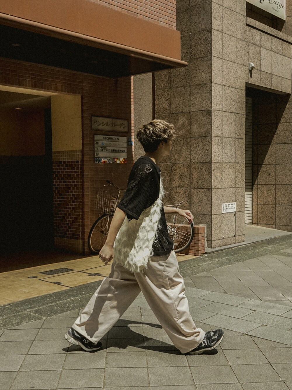 ブラック系のシャツ/ブラウス、ベージュ系のその他パンツ、ホワイト系のショルダーバッグを着用したメンズの春コーディネートの3枚目の写真