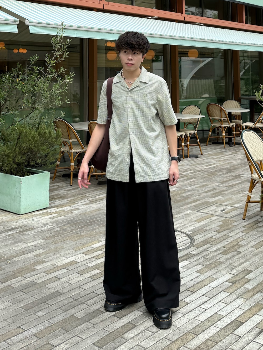 グリーン系のシャツ/ブラウス、ブラック系のスラックス、ブラウン系のトートバッグを着用したメンズの夏コーディネートの2枚目の写真