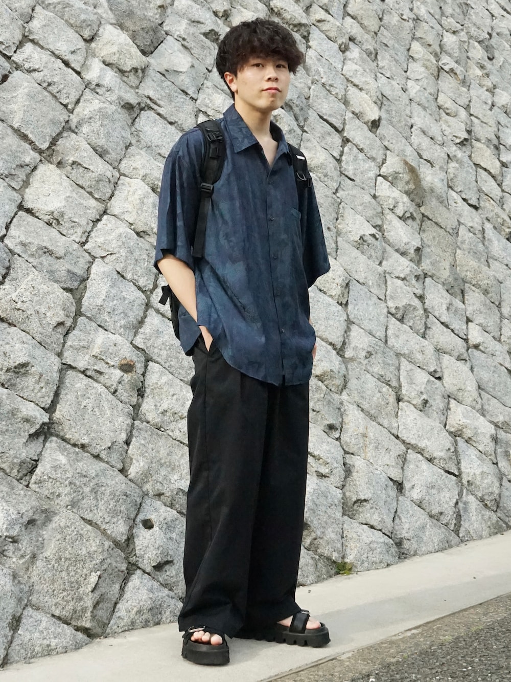 グリーン系のシャツ/ブラウス、グレー系のタンクトップ、ブラック系のバックパック/リュックを着用したメンズの春コーディネートの3枚目の写真