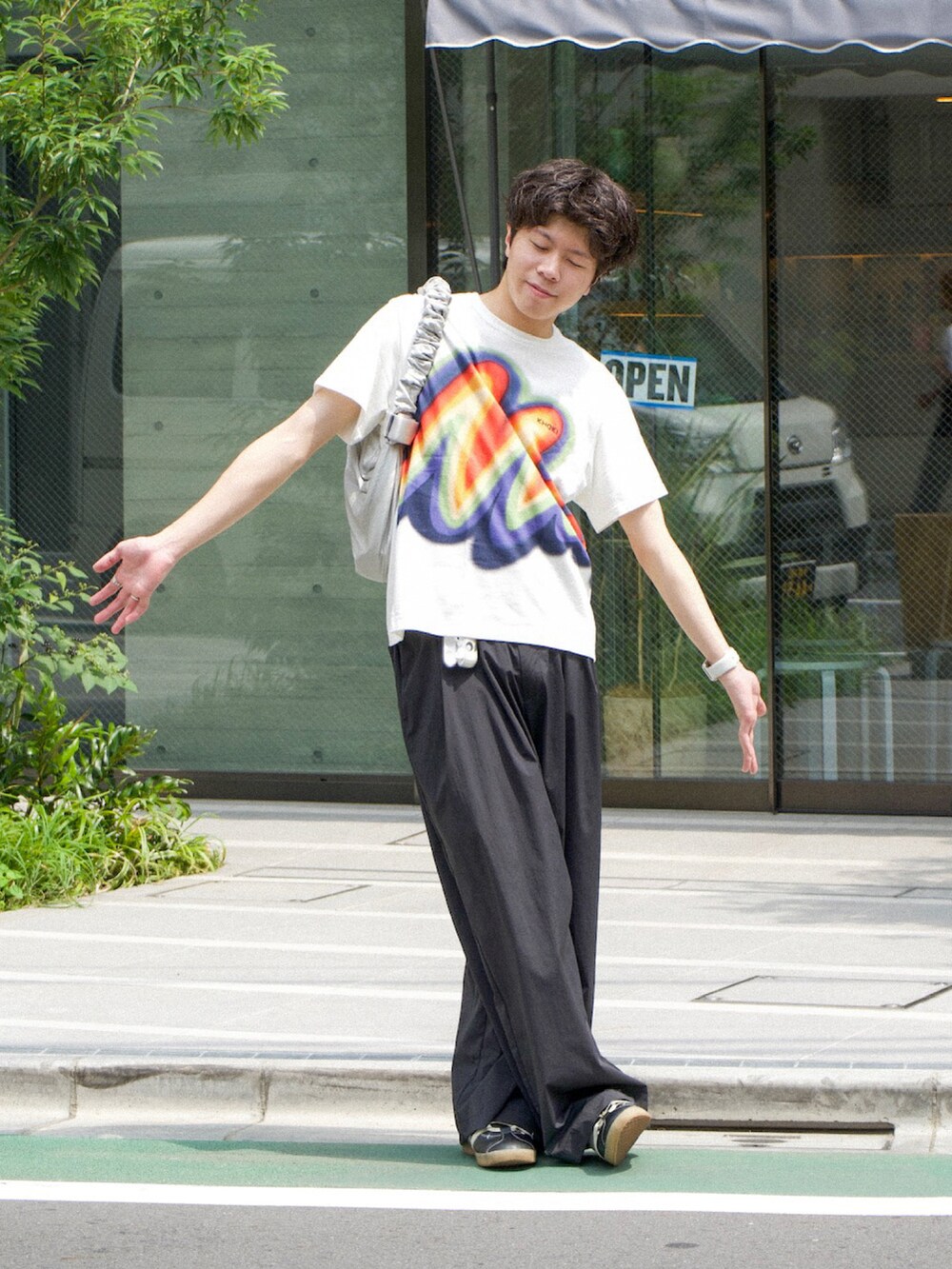ホワイト系のTシャツ/カットソー、ブラック系のスラックス、ブラック系のスニーカーを着用したメンズの夏コーディネートの2枚目の写真