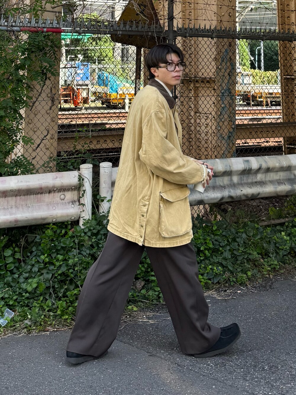 ブラック系のモカシン/デッキシューズ、イエロー系のデニムジャケット、ブラウン系のサングラスを着用したメンズの秋コーディネートの2枚目の写真