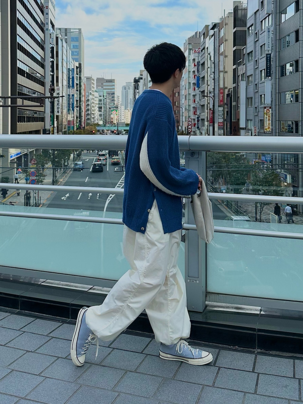 ブルー系のニット/セーター、ホワイト系のカーゴパンツ、グレー系のスニーカーを着用したメンズの秋コーディネートの2枚目の写真