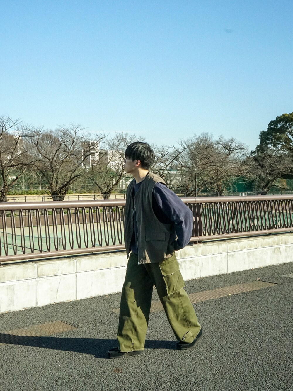 グレー系のベスト、ブルー系のスウェット、グリーン系のカーゴパンツを着用したメンズの冬コーディネートの3枚目の写真