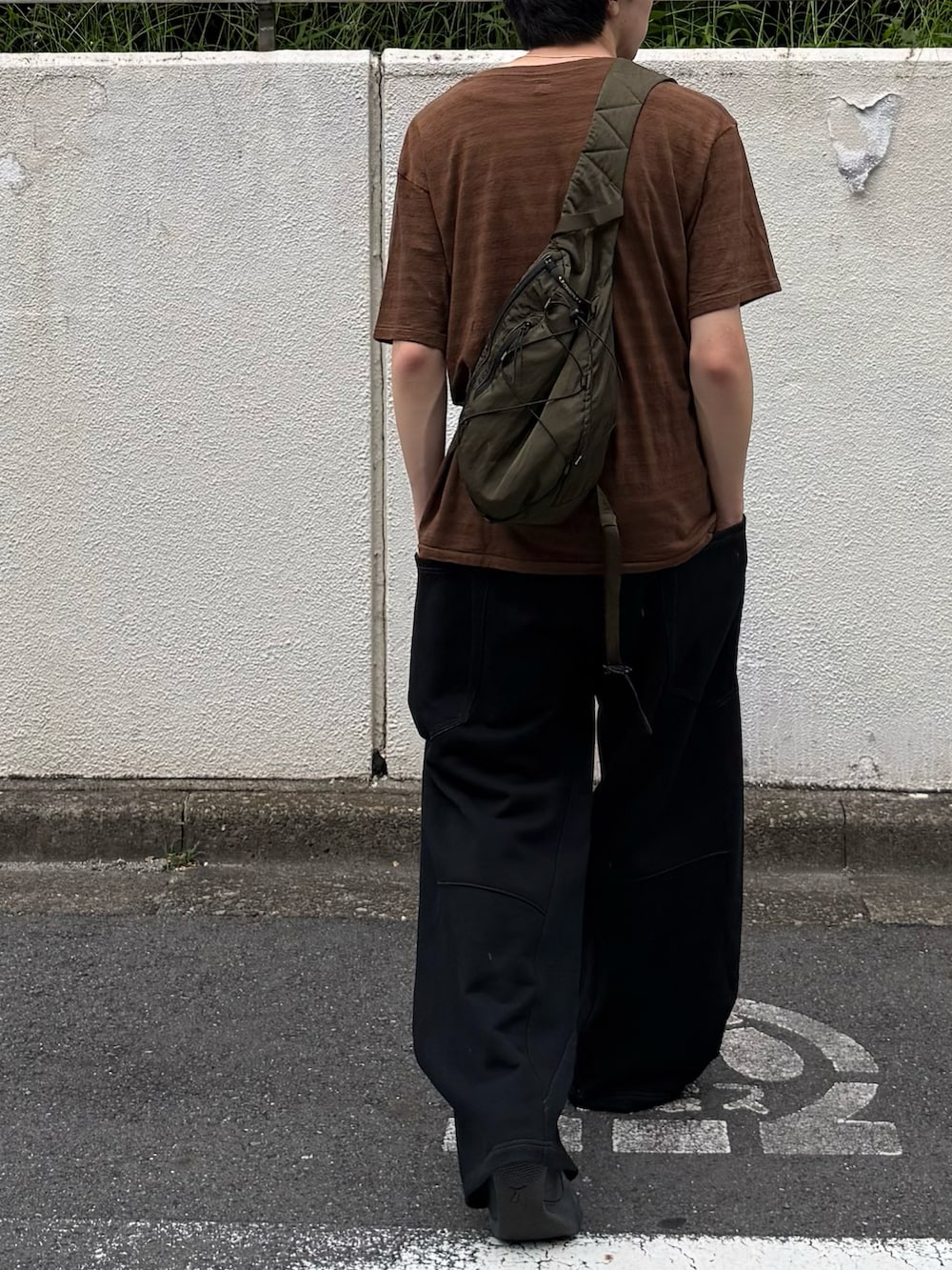ブラウン系のTシャツ/カットソー、ブラック系のスウェットパンツ、グリーン系のバックパック/リュックを着用したメンズの夏コーディネートの3枚目の写真