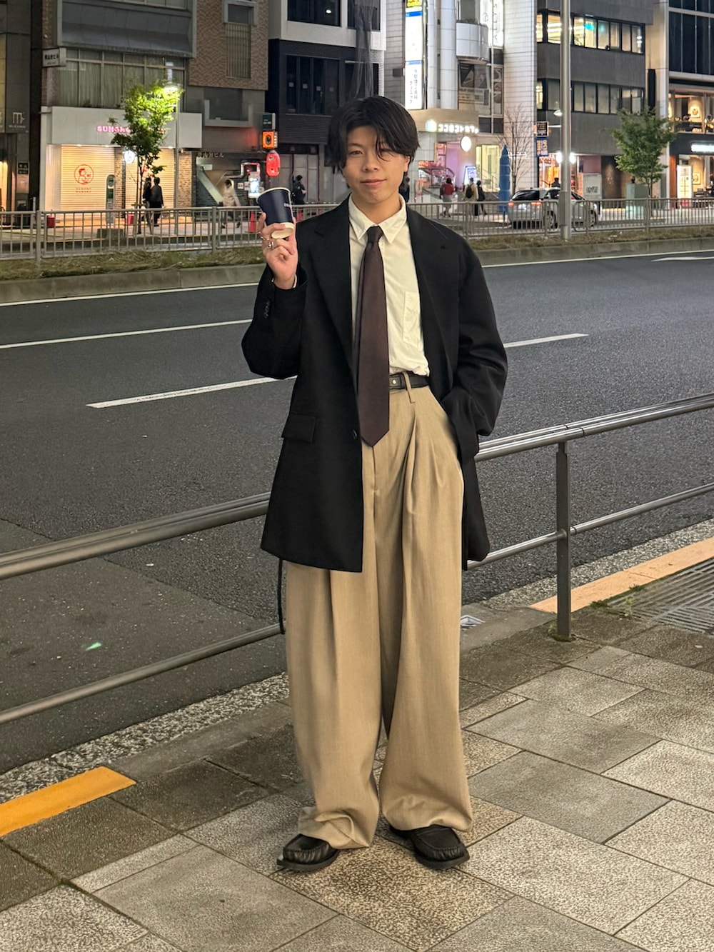 ブラック系のテーラードジャケット、ホワイト系のシャツ/ブラウス、ベージュ系のスラックスを着用したメンズの春コーディネートの2枚目の写真