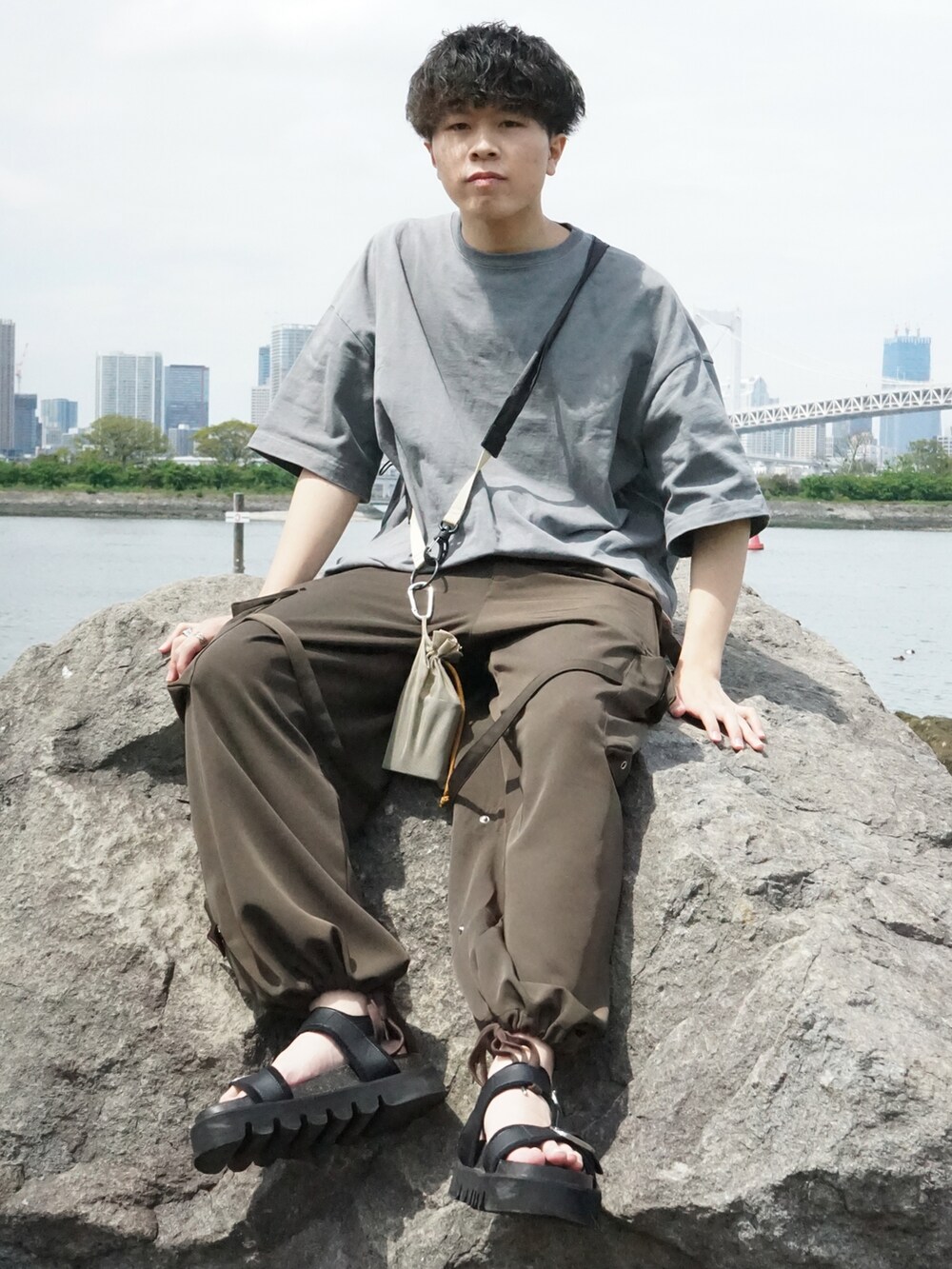 グレー系のTシャツ/カットソー、ベージュ系のショルダーバッグ、グリーン系のサロペット/オーバーオールを着用したメンズの春コーディネートの3枚目の写真