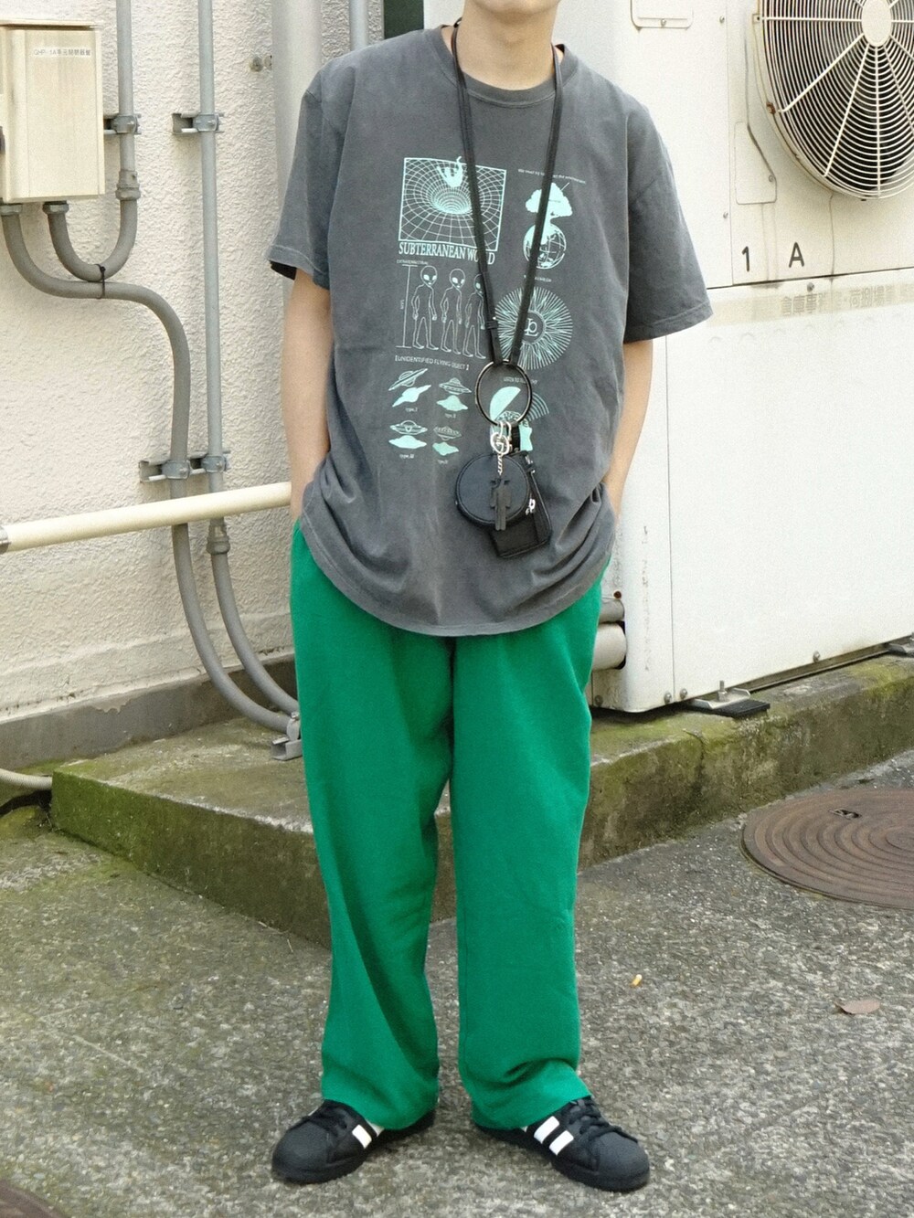 グレー系のTシャツ/カットソー、グリーン系のその他パンツ、ブラック系のショルダーバッグを着用したメンズの夏コーディネートの5枚目の写真