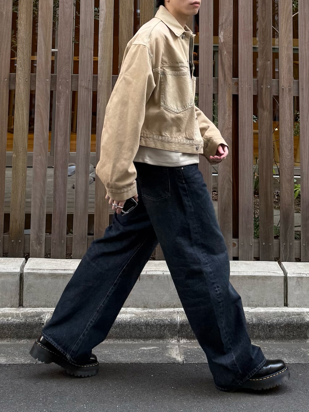 ベージュ系のTシャツ/カットソー、ブルー系のデニムパンツ、ブラック系のブーツを着用したメンズの春コーディネートの4枚目の写真