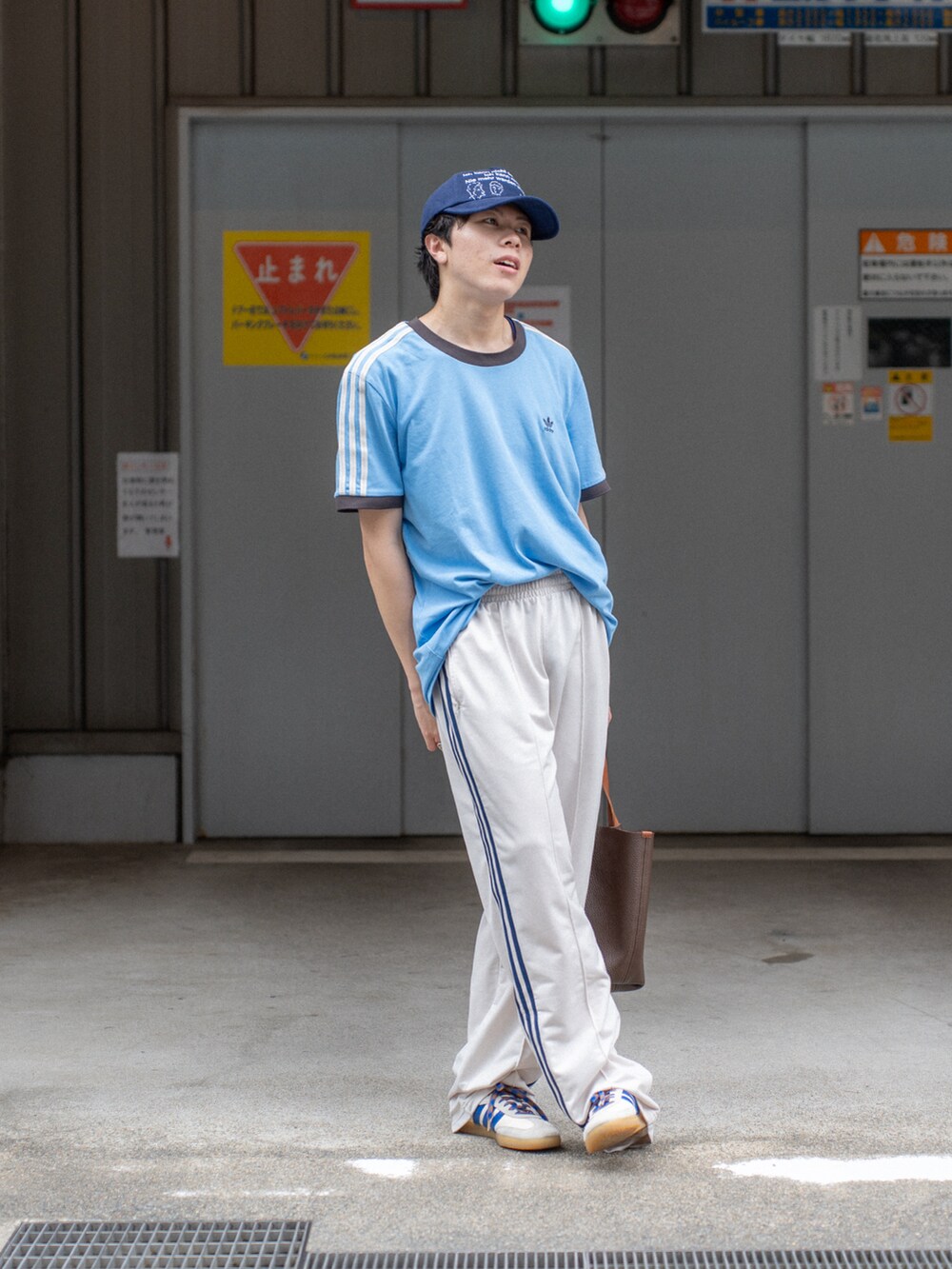 ブルー系のTシャツ/カットソー、ホワイト系のその他パンツ、ブラウン系のハンドバッグを着用したメンズの夏コーディネートの2枚目の写真