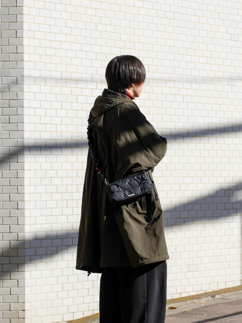 ブラック系のスウェット、ブラック系のショルダーバッグ、ブラック系のスウェットパンツを着用したメンズの冬コーディネートの4枚目の写真