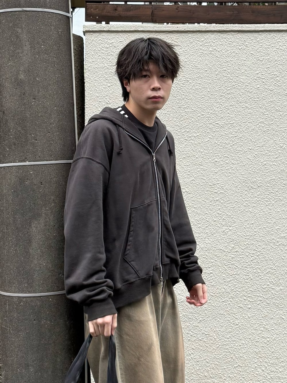 ブラック系のパーカー、ブラック系のTシャツ/カットソー、ブルー系のデニムパンツを着用したメンズの春コーディネートの3枚目の写真