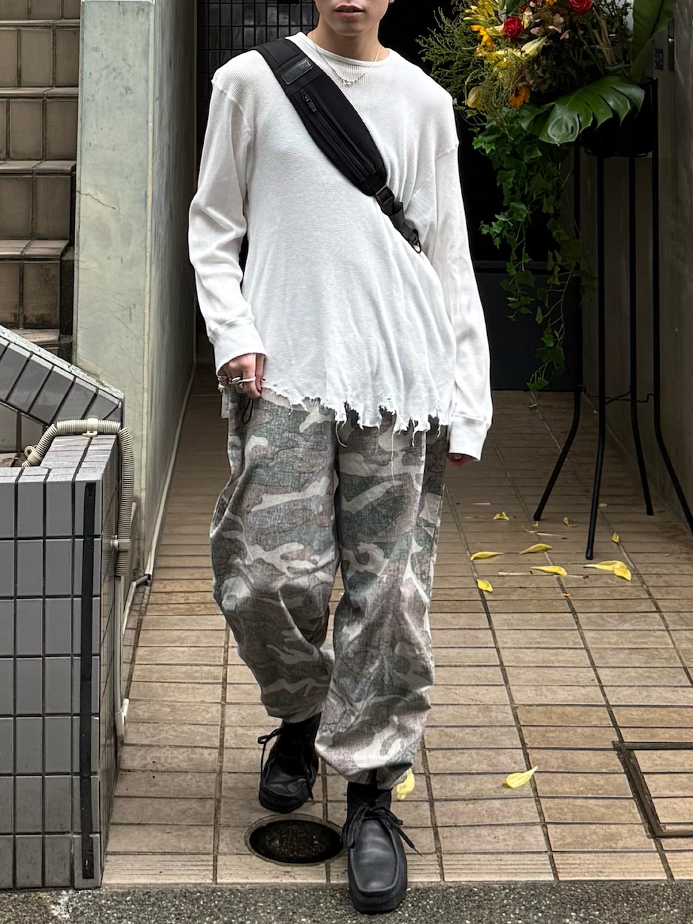 ホワイト系のTシャツ/カットソー、ブラック系のショルダーバッグ、ブラック系のブーツを着用したメンズの秋コーディネートの4枚目の写真