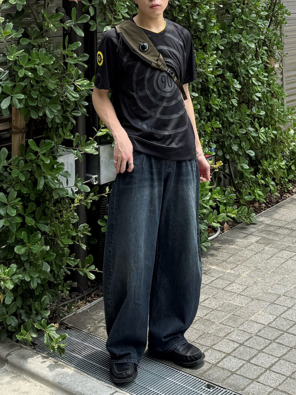 ブラック系のジャージ、ブルー系のデニムパンツ、グリーン系のバックパック/リュックを着用したメンズの夏コーディネートの3枚目の写真