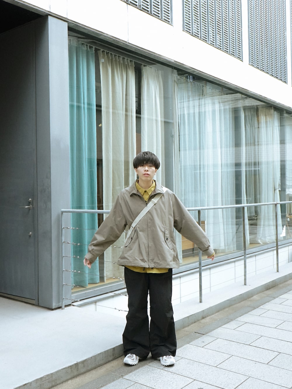 グリーン系のブルゾン、イエロー系のシャツ/ブラウス、ブラック系のその他パンツを着用したメンズの春コーディネートの3枚目の写真