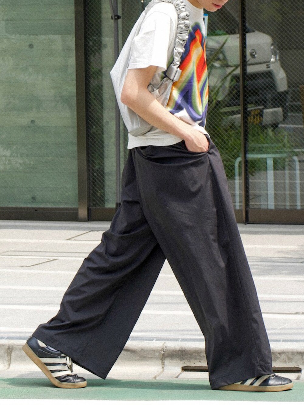 ホワイト系のTシャツ/カットソー、ブラック系のスラックス、ブラック系のスニーカーを着用したメンズの夏コーディネートの5枚目の写真