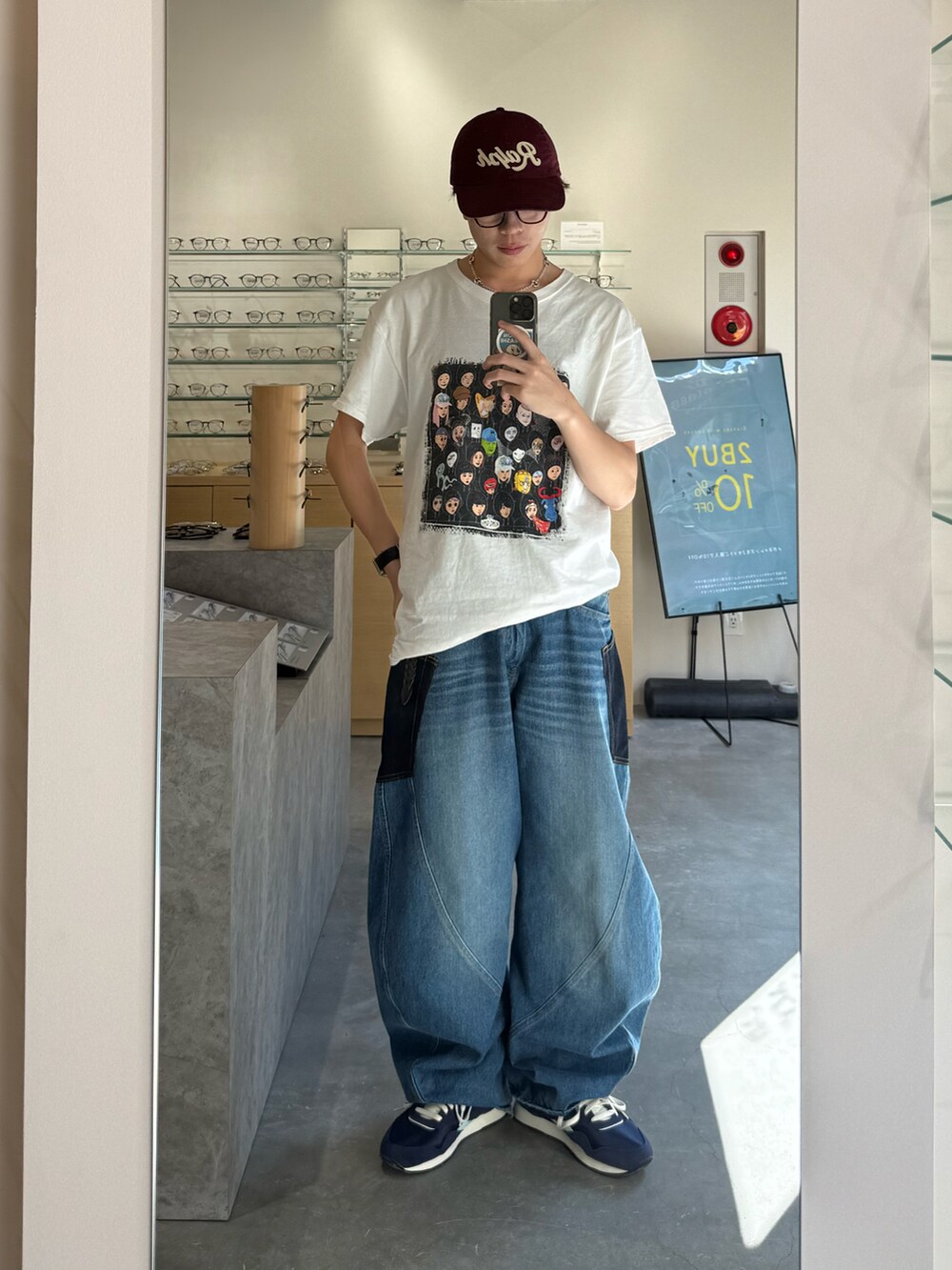 ブルー系のデニムパンツ、ブラック系のデジタル腕時計、レッド系のキャップを着用したメンズの夏コーディネートの2枚目の写真