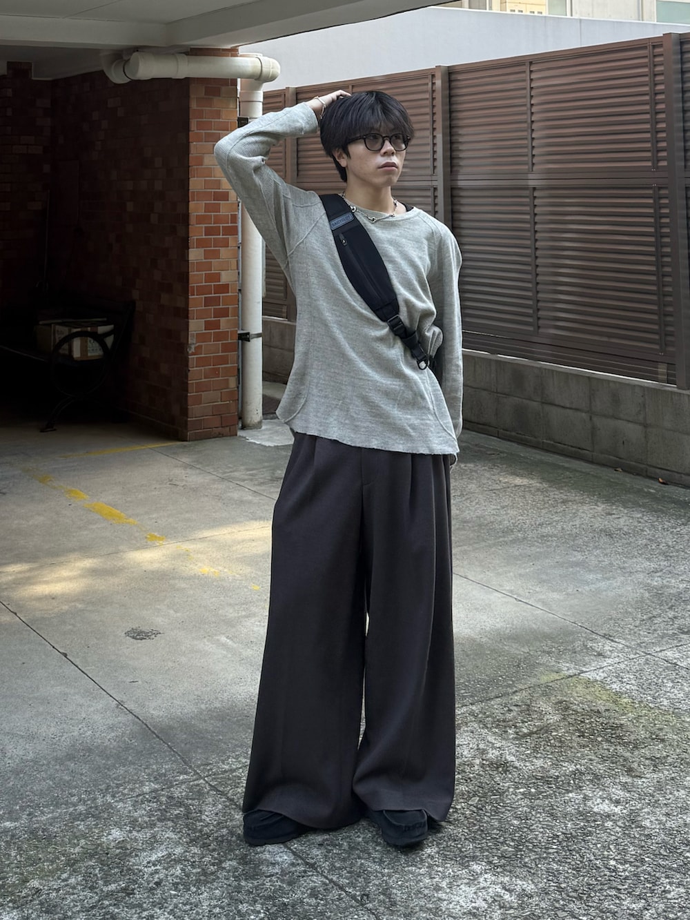 グレー系のTシャツ/カットソー、ブラウン系のスラックス、ブラック系のモカシン/デッキシューズを着用したメンズの秋コーディネートの2枚目の写真