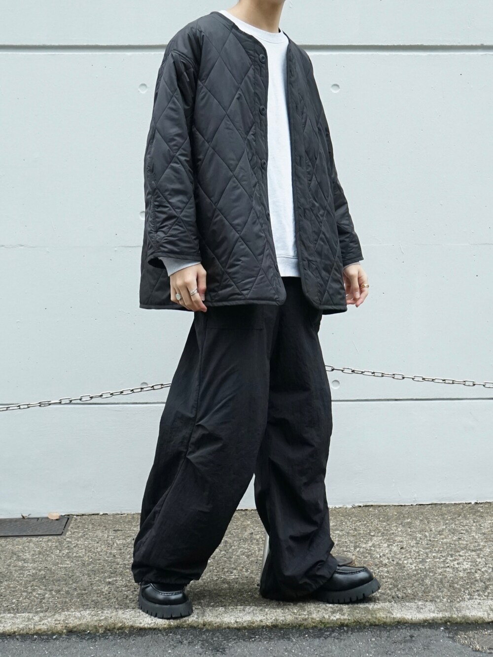 グレー系のスウェット、ブラック系のその他パンツ、ブラック系のローファーを着用したメンズの秋コーディネートの5枚目の写真