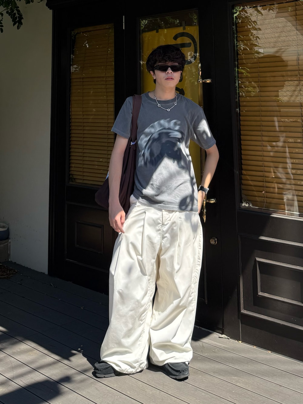 ホワイト系のその他パンツ、ブラウン系のトートバッグ、ブラック系のモカシン/デッキシューズを着用したメンズの夏コーディネートの2枚目の写真