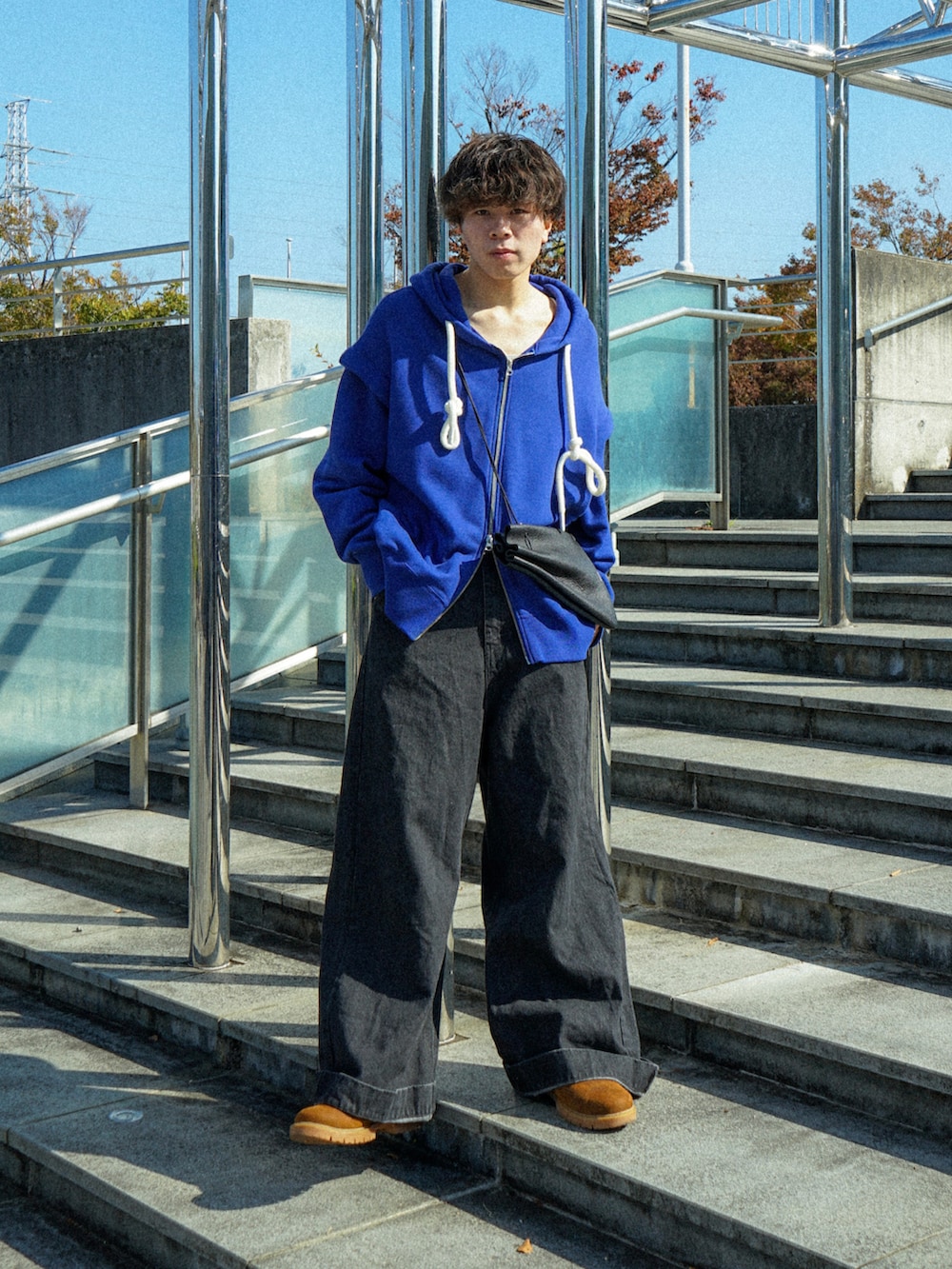 ブルー系のパーカー、ブラック系のデニムパンツ、ブラック系のショルダーバッグを着用したメンズの秋コーディネートの2枚目の写真